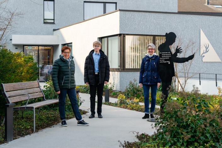 Drei Personen aus dem Team der Eckhirsch putzART und Immobilien AG posieren mit einer Silhouette vor dem Firmengebäude.