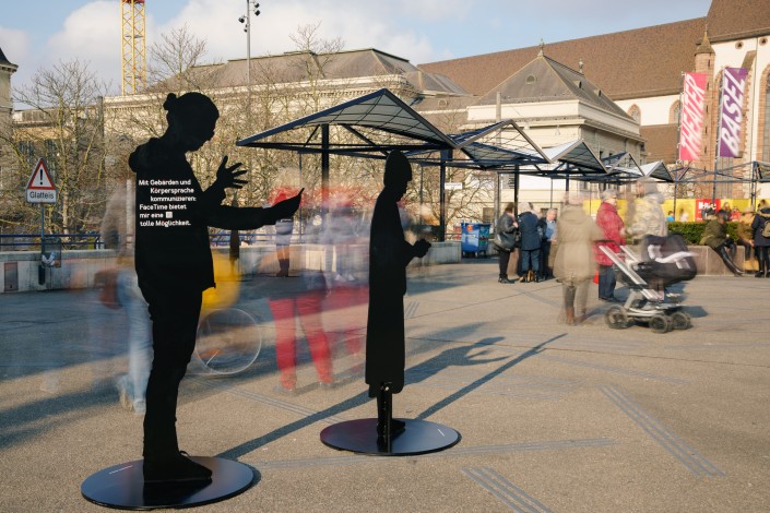 Das Foto zeigt 2 Silhouetten auf dem Basler Theaterplatz